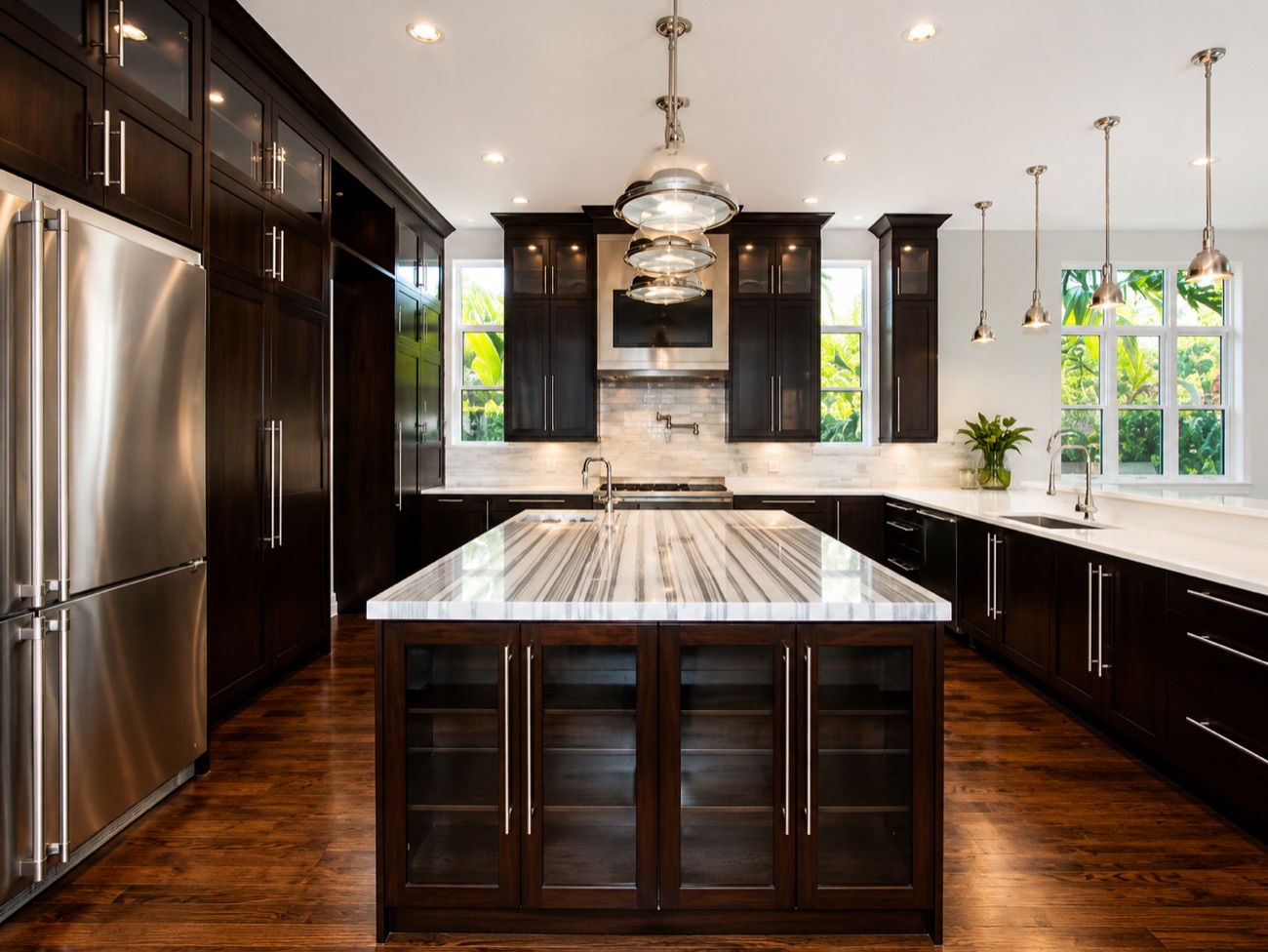 Custom kitchen with marble island and dark cabinetry