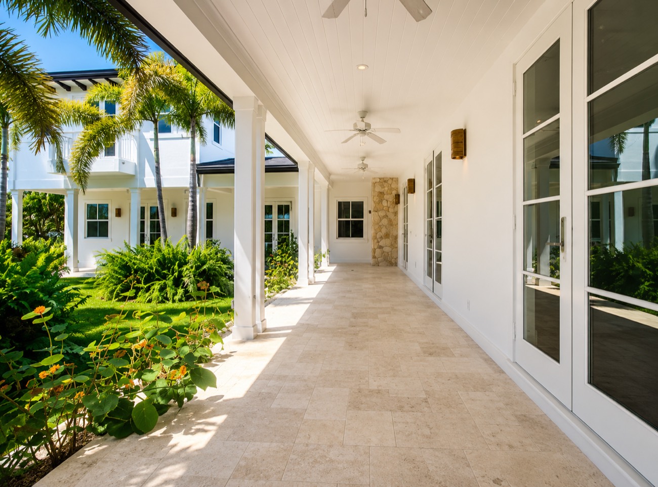 Covered travertine loggia framed by palms
